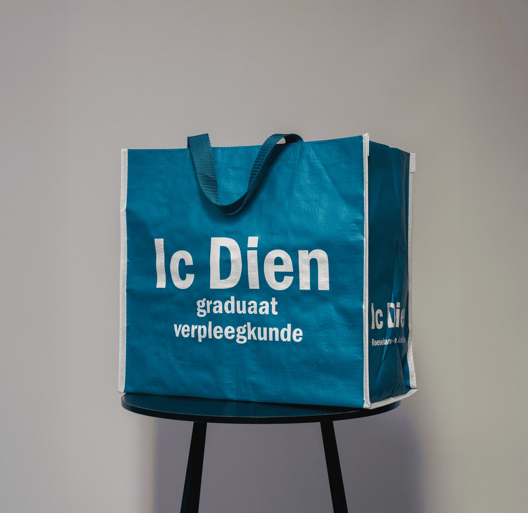 Blauwe woven draagtas met witte opdruk van Ic Dien Roeselare, opleiding graduaat verpleegkunde